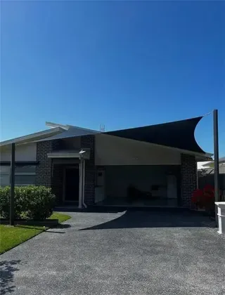 Black shade sails over a residential pool courtyard