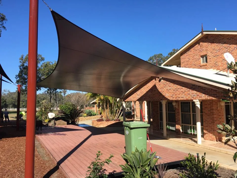 Brown shade sail over a brick home verandah