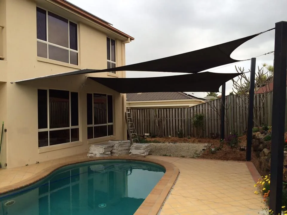 Charcoal waterproof sail over a tiled poolside courtyard