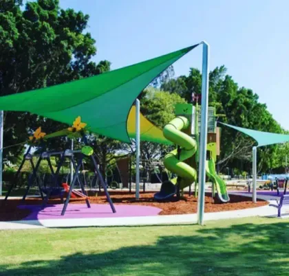 Green shade sails over a community playground