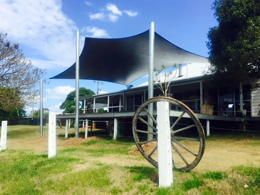 Grey shade sails covering a brick home driveway