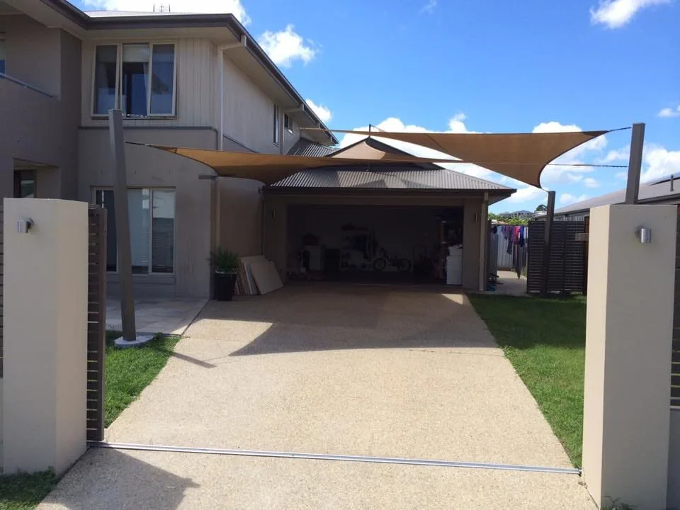 Cream shade sails over a modern home driveway and carport