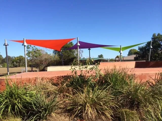 Multicoloured shade sails over a public community space