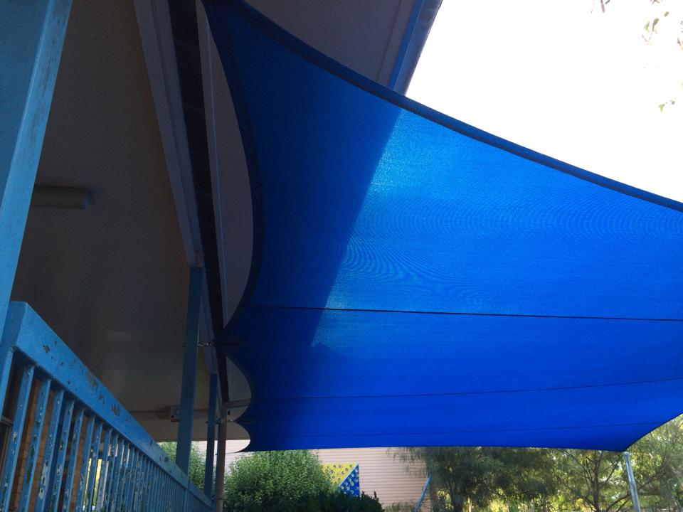 Custom residential shade sail tensioned over a backyard outdoor area